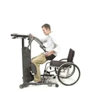 Ein Mann der sich gerade mithilfe eines Hebels am EasyStand Strapstand aus einem Rollstuhl hochzieht. Druch den Hebel bewegt sich der Gesäßgürtel nach oben vorne bis zum aufrechten Stand.