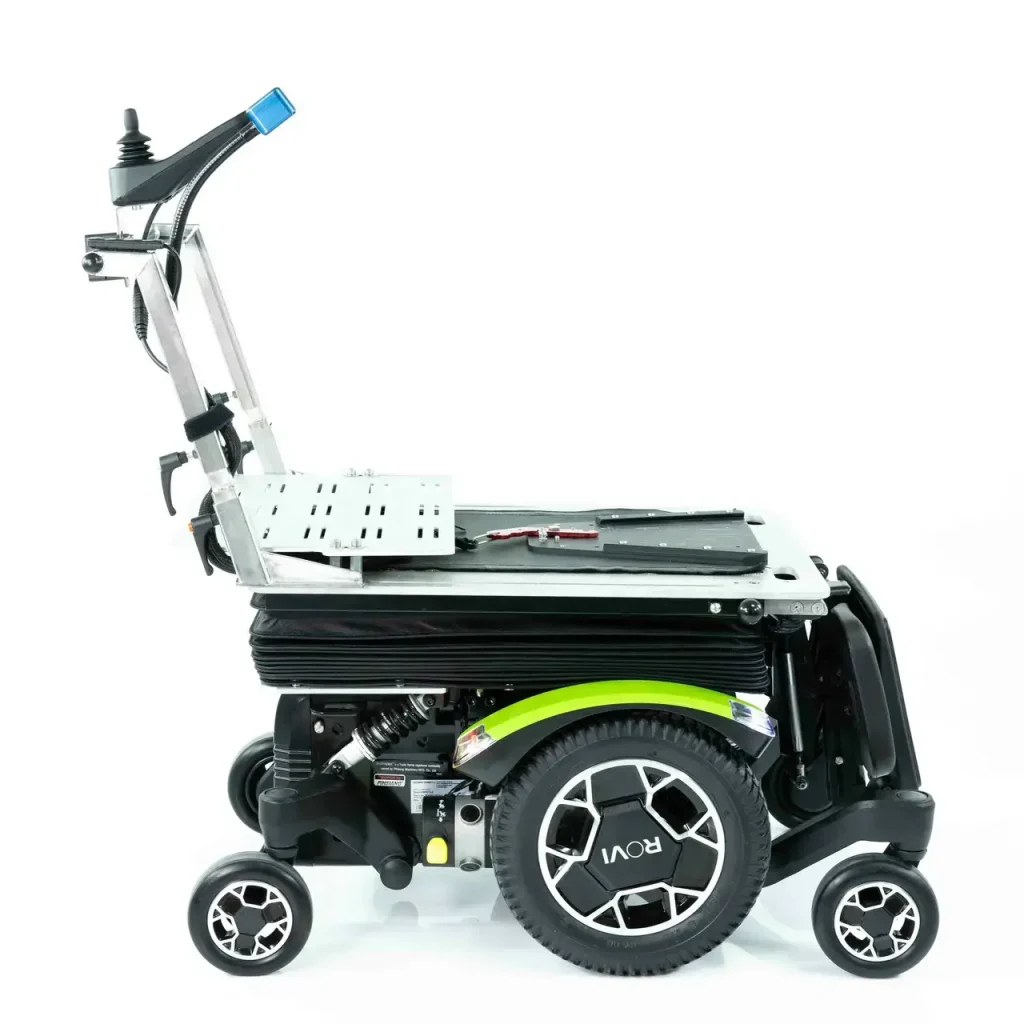 ROVI-Basis Seitenansicht. Darauf der COSEAT mit sichtbarer Montage-Schiene für eine Sitzschale. An der Rückseite ist ein höhenverstellbarer Griff mit den Bedienelementen.